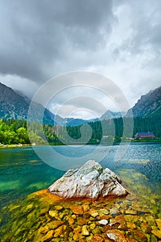 Fantastické horské jezero. Lesní jezero s kameny vysoko v horách. Místo pro turistiku, hotely a chaty u jezera. velký