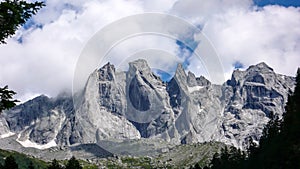 Fantastic mountain landscape in the Swiss Alps with jagged sharp granite peaks under a cloudy sky