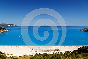 Fantastic panoramic top view at Myrtos Beach with turquoise and blue Ionian Sea water. Summer scenery of famous and