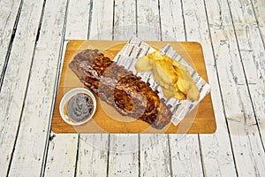 Fantastic roast pork ribs with french fries on wooden board