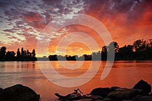A fantastic sunset at river Rhine. Orange and red clouds reflecting in the water. Germany, Baden-Wuerttemberg