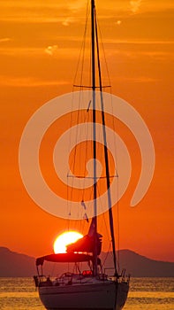 Fantastic sunset by the sea with sailing yacht in the foreground.