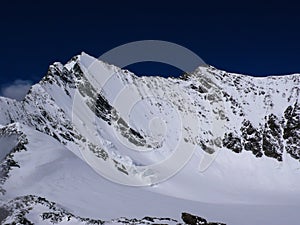 View of the Lenzspitze mountain peak and northeast face under a blue sky in the Alps of Switzerland