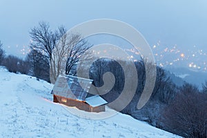 Fantastic winter landscape with glowing wooden house