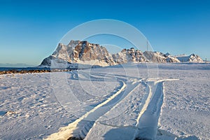 Fantastic winter scenery on Uttakleiv beach at morning with car tracks