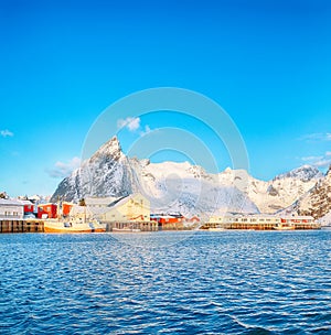 Fantastic winter view on Hamnoy village with port and  Olstinden peak on background