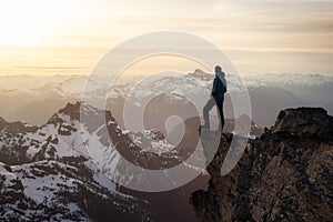 Fantasy Adventure Composite with a Man on top of a Mountain Cliff