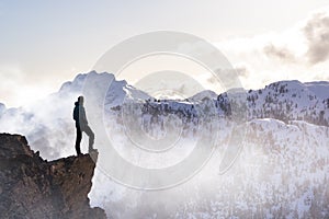 Fantasy Adventure Composite with a Man on top of a Mountain Cliff photo