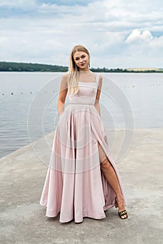 fantasy charming woman in elegant ping evening dress relaxing near lake