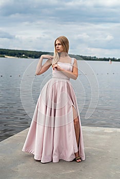 fantasy charming woman in elegant ping evening dress relaxing near lake