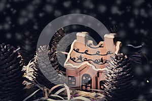 Fantasy christmas winter card with brown ceramic house and fir tree of cones