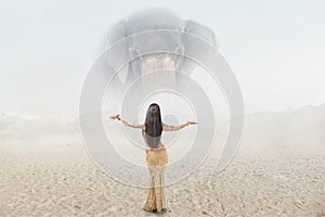 Fantasy fashion portrait of young woman posing in front of giant elephant