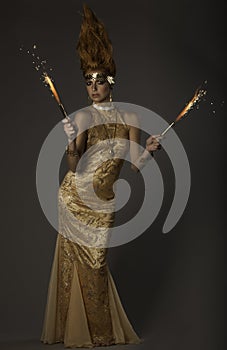 Fantasy image of flame-throwing woman in gold couture