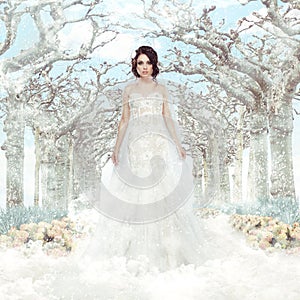 Fantasy. Matrimony. Bride in White Dress over Frozen Winter Trees and Snowflakes photo