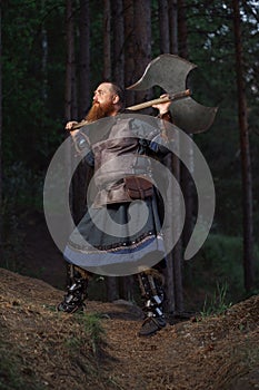 Fantasy medieval red-haired gnome warrior with beard with huge ax halberd in forest