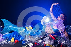 Fantasy mermaid in deep ocean sad because water pollution. Plastic trash and bottles pollution in ocean. Ecocatastrophe