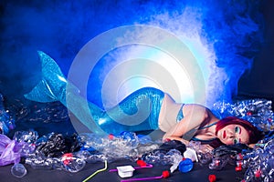 Fantasy mermaid in deep ocean sad because water pollution. Plastic trash and bottles pollution in ocean. Ecocatastrophe