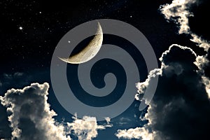 A fantasy of night sky cloudscape with stars and a crescent moon overlaid photo