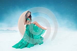 Fantasy portrait of a beautiful tanned brunette girl in a turquoise Oriental dress and jewelry