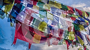 Fantasy scene of colorful praying flags with blue sky in the background.