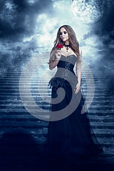 Fantasy Woman in Black Dress Smelling Rose Flower, Mystic Girl in Long Retro Gothic Gown