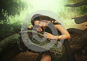 Fantasy woman evil dark queen witch hugs dragon, touching with hands head. Girl mistress tamed myth monster, concept of