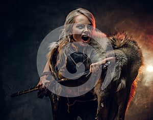 Fantasy woman knight wearing cuirass and fur, holding a sword and rushes into battle with a furious cry. Cosplayer as