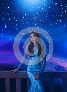 Fantasy woman princess stands on balcony looks at night sky space cosmos stars. Girl enjoy magic starfall ball. Elegant photo