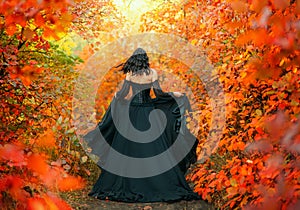 Fantasy woman runs in autumn magic forest back rear view Long gothic black silk dress flies in wind lady witch art old