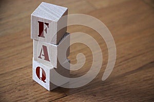 FAQ abbreviation made of wooden cubes on an office table. Business concept