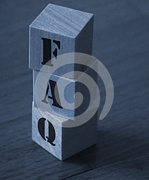 FAQ abbreviation made of wooden cubes on an office table. Business concept