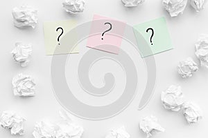 FAQ concept. Question mark on sticky notes near crumpled paper on white background top view copy space