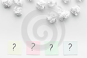 FAQ concept. Question mark on sticky notes near crumpled paper on white background top view copy space