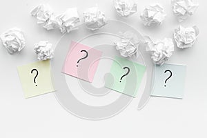 FAQ concept. Question mark on sticky notes near crumpled paper on white background top view copy space