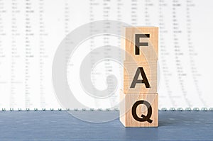 FAQ on wooden cubes on grey backround. Business concept