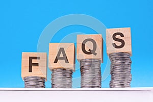 faqs - text on wood cubes stack with coins