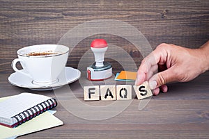 Faqs. Wooden letters on dark background