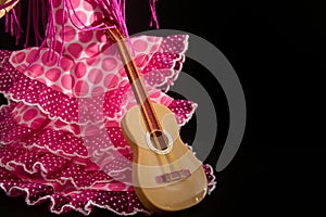 Faralaes costume for a flamenco dancer with a guitar. Black background with copy space
