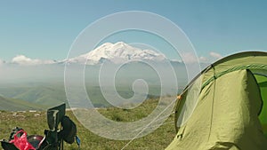 Faraway view of elbrus covered with snow and touristic equipment on plateau Bermamyth