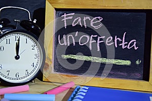 Fare un`offerta in italian on phrase colorful handwritten on blackboard. photo