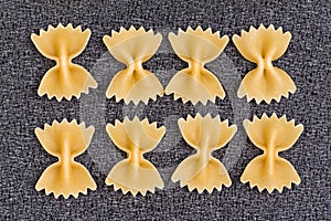 Farfalle closeup on grey background. Raw pasta bow tie. food background