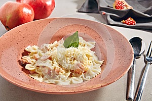 Farfalle Pasta Al Dente with Salmon in Cream Sauce on Rustic Plate