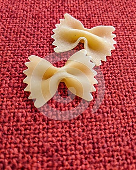 Farfalle Pasta Closeup on red textile background