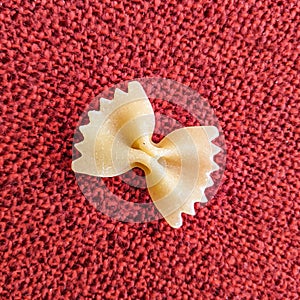 Farfalle Pasta Closeup on red textile background