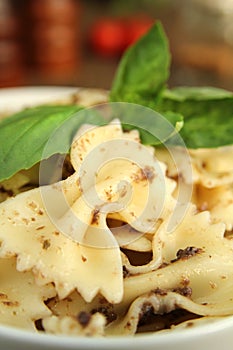 Farfalle pasta with fresh pesto serve in a white bowl