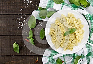 Farfalle pasta with pesto genovese & x28;basil sauce& x29; on rustic wood