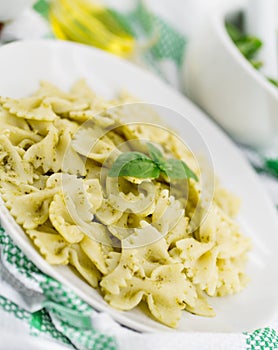 Farfalle pasta with pesto genovese basil sauce on white rusti