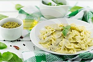 Farfalle pasta with pesto genovese basil sauce on white rusti