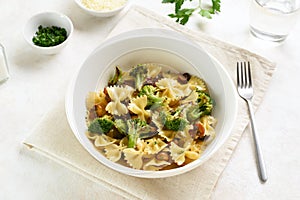 Farfalle pasta with roasted broccoli and mushrooms in bowl