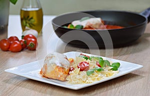 Farfalle pasta in tomato sauce with chicken, basil in plate